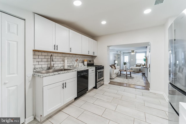 kitchen featuring stainless steel appliances, light tile patterned floors, white cabinets, ceiling fan, and sink