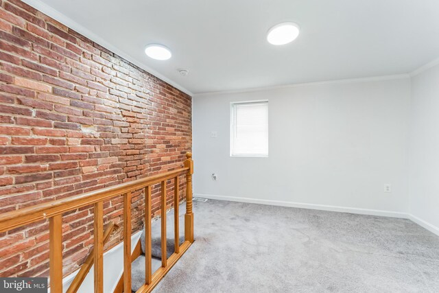 hallway with brick wall, ornamental molding, and carpet floors