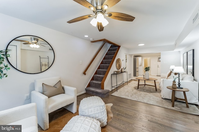 living room with dark wood-type flooring and ceiling fan