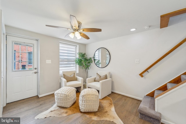 living area featuring light hardwood / wood-style flooring and ceiling fan