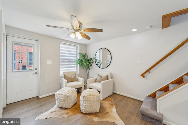 sitting room with ceiling fan and light wood-type flooring