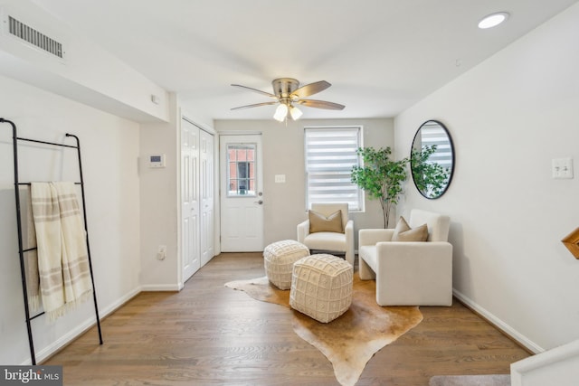 living area with ceiling fan and hardwood / wood-style flooring