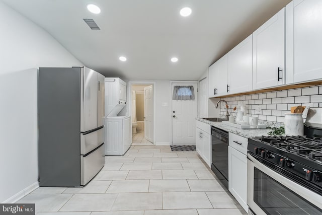 kitchen featuring white refrigerator, light stone counters, light tile patterned floors, sink, and gas stove