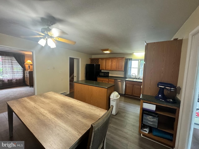 dining space with a baseboard heating unit, dark hardwood / wood-style flooring, sink, and ceiling fan