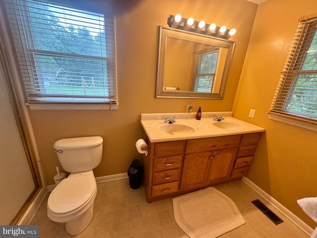 bathroom featuring dual vanity, tile patterned flooring, and toilet