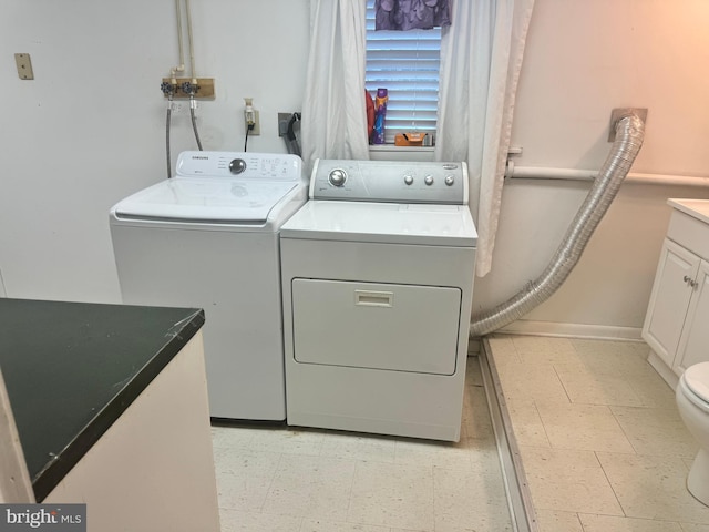 clothes washing area with light tile patterned floors and washer and dryer