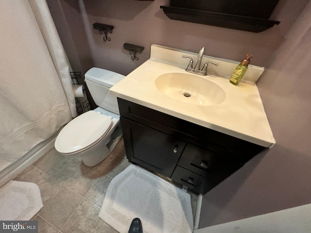 bathroom featuring toilet, vanity, and tile patterned flooring