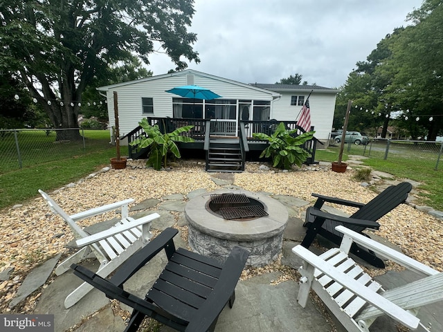 back of property featuring a patio area, a wooden deck, and a fire pit