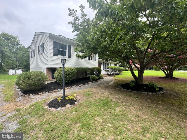 view of side of property with a shed and a yard