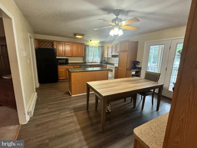 dining area with ceiling fan, sink, dark wood-type flooring, and a textured ceiling