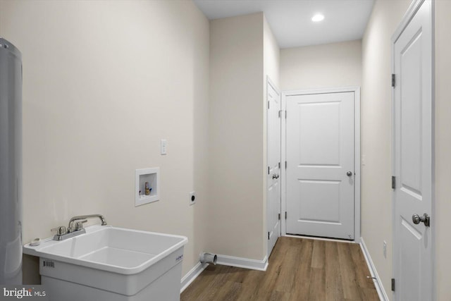 laundry area featuring hookup for a washing machine, hookup for an electric dryer, a sink, wood finished floors, and laundry area