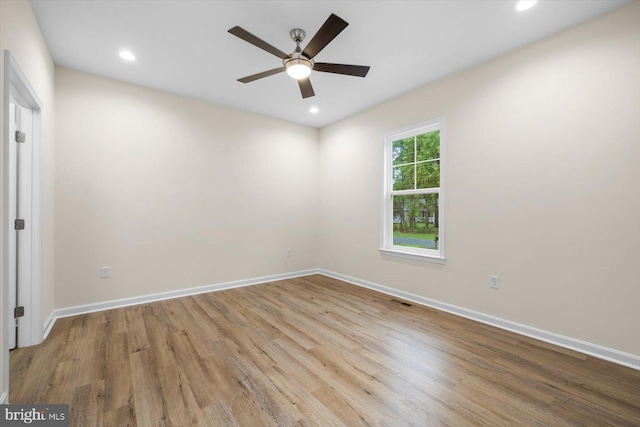 empty room featuring recessed lighting, wood finished floors, and baseboards