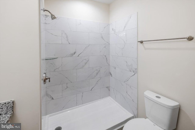 bathroom featuring toilet and a tile shower