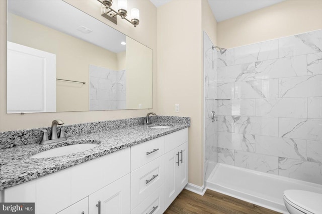 bathroom with double sink vanity, hardwood / wood-style floors, and toilet