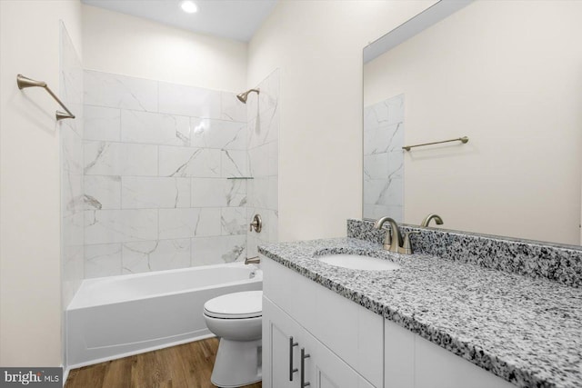 full bathroom featuring vanity, bathing tub / shower combination, wood finished floors, and toilet