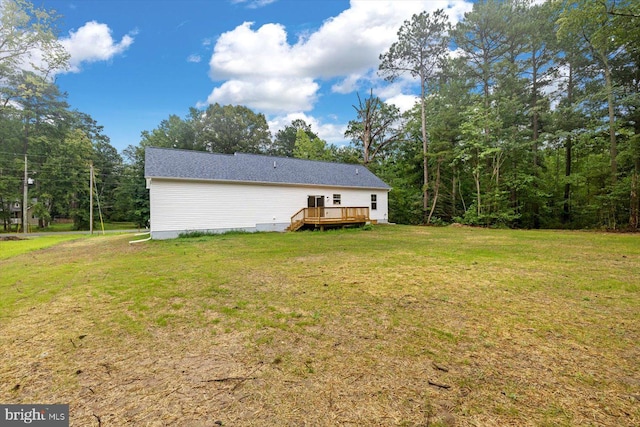 rear view of house featuring a yard and a wooden deck