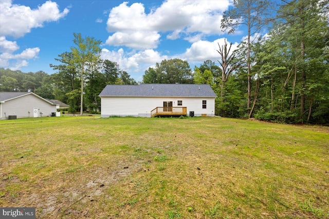 back of property featuring a deck and a lawn