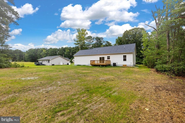 rear view of property featuring crawl space, a deck, and a yard