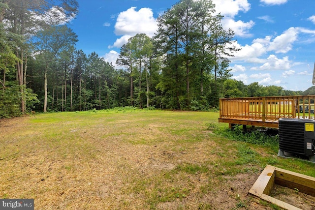 view of yard with central AC and a deck