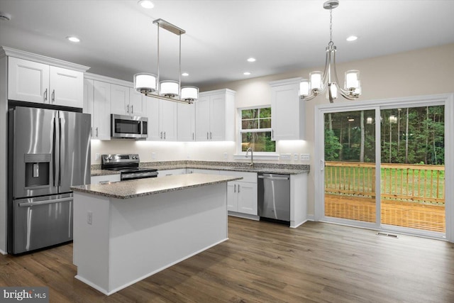 kitchen with white cabinets, visible vents, stainless steel appliances, and a center island