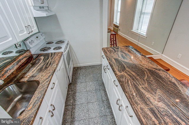 kitchen featuring dark stone counters, white cabinetry, tile patterned floors, and white range with electric cooktop