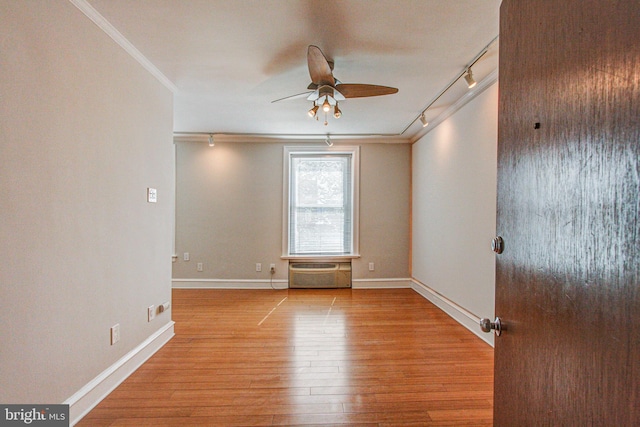 unfurnished room featuring rail lighting, ornamental molding, ceiling fan, and light hardwood / wood-style floors