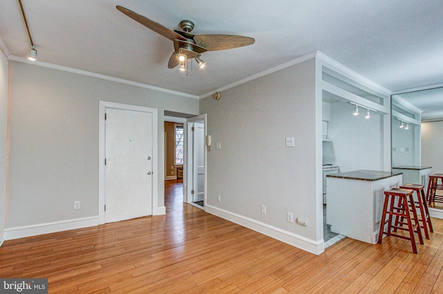 interior space with light hardwood / wood-style flooring, ornamental molding, ceiling fan, and rail lighting