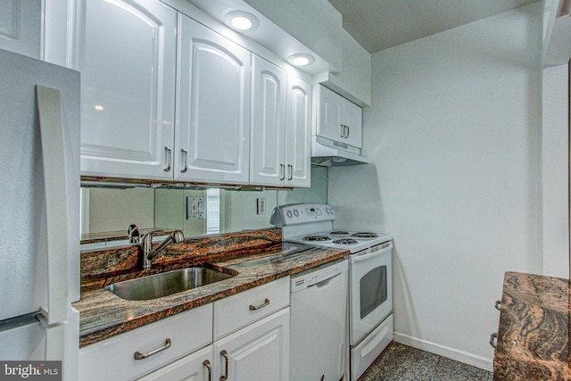 kitchen with white appliances, sink, tile patterned floors, dark stone countertops, and white cabinetry