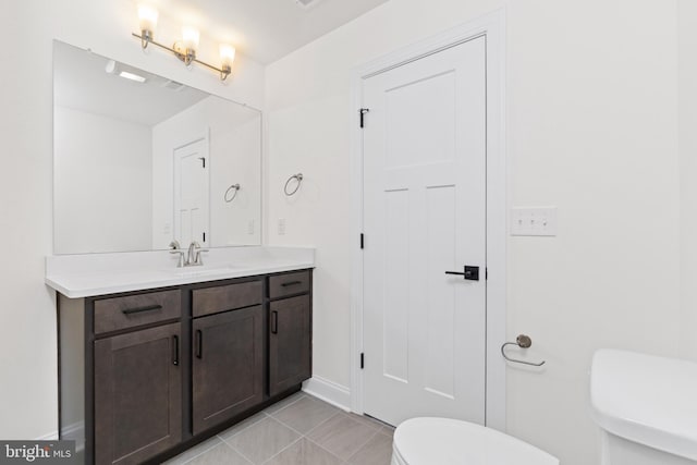 bathroom with tile patterned flooring, vanity, and toilet