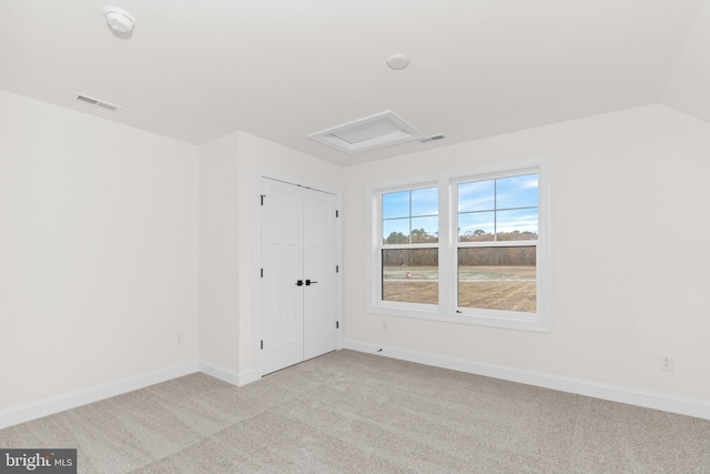 spare room with lofted ceiling and light carpet