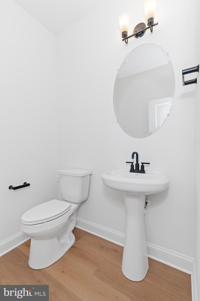 bathroom with wood-type flooring and toilet