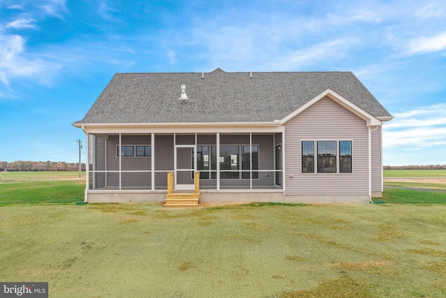 rear view of house featuring a lawn and a sunroom