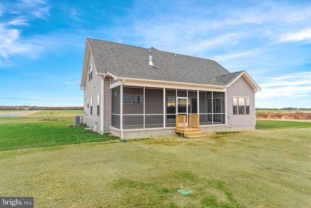 rear view of property featuring a lawn, a sunroom, and cooling unit