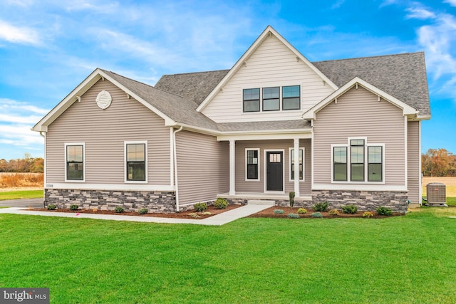 craftsman-style home with central air condition unit and a front yard