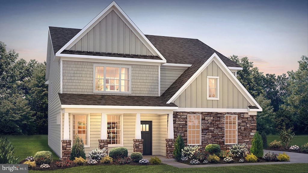 craftsman inspired home featuring a porch and a lawn