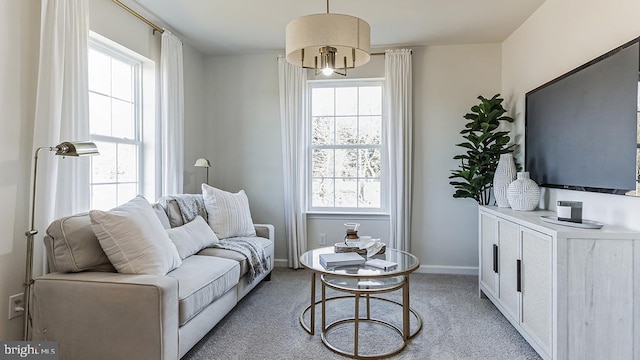 living room with light colored carpet, a chandelier, and plenty of natural light