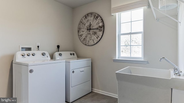 laundry room with washing machine and clothes dryer, sink, and light tile patterned floors