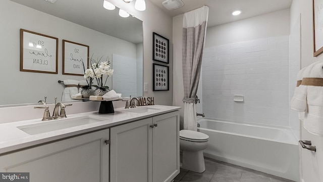 full bathroom featuring dual vanity, toilet, tile patterned floors, and shower / tub combo