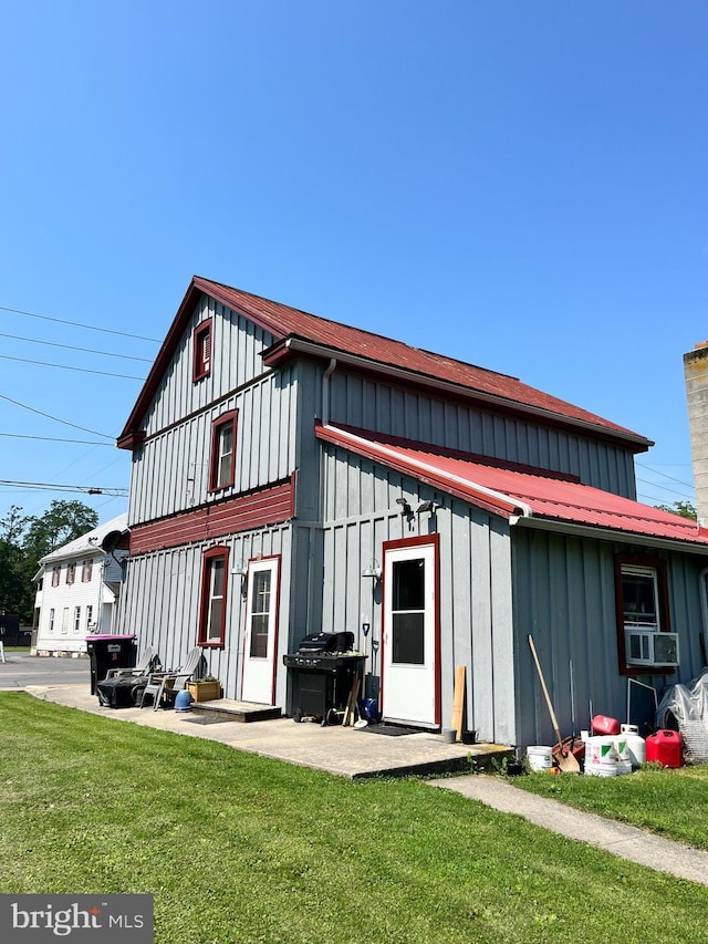 rear view of property featuring a lawn and a patio