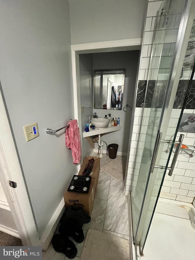 bathroom featuring sink and a shower with door