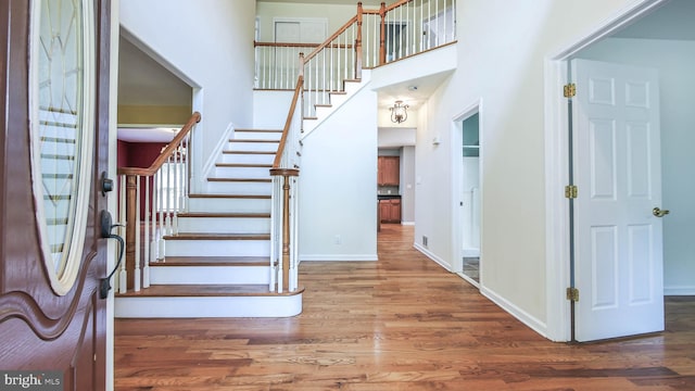 foyer featuring hardwood / wood-style flooring and a towering ceiling