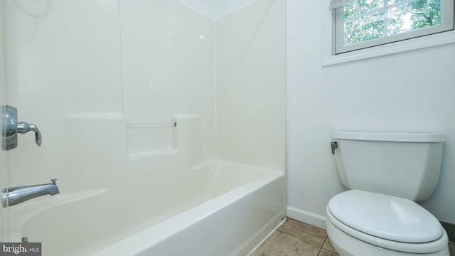 bathroom with tile patterned flooring, shower / bathing tub combination, and toilet