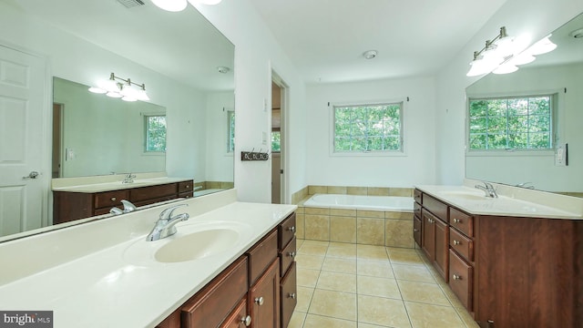 bathroom with tiled tub, a wealth of natural light, and double sink vanity