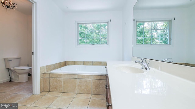 bathroom with vanity, tile patterned floors, tiled tub, and toilet