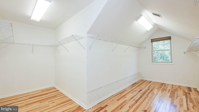 spacious closet with vaulted ceiling and hardwood / wood-style floors