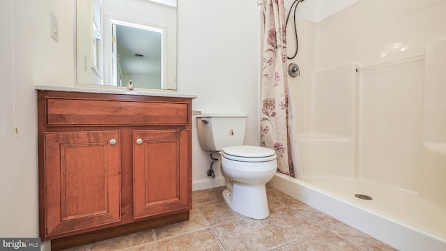 bathroom with vanity, toilet, tile patterned floors, and walk in shower