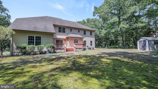 view of front of property with a deck, a storage unit, and a front yard