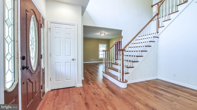 entrance foyer with hardwood / wood-style floors and a high ceiling