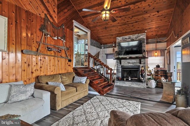 living room featuring a fireplace, ceiling fan, wooden ceiling, wood walls, and dark wood-type flooring