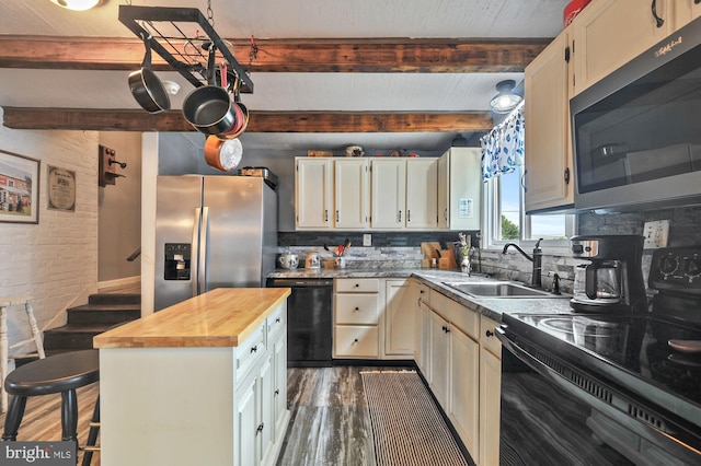 kitchen with dark hardwood / wood-style flooring, beamed ceiling, black appliances, decorative backsplash, and butcher block countertops